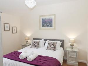 Schlafzimmer mit einem Bett mit weißer Bettwäsche und Kissen in der Unterkunft Hazelnut Lodge in Crediton