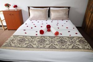 een bed met twee rode bloemen erop bij Dawn's Bungalow in Nuwara Eliya