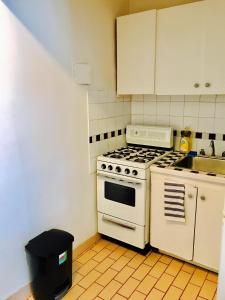 uma cozinha com um fogão branco e um lavatório em Stylish Montreal Apartment: Comfortable Stay in the Golden Square Mile em Montreal