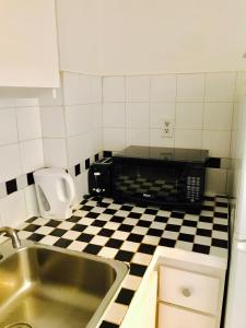 a kitchen with a sink and a black and white checkered floor at Stylish Montreal Apartment: Comfortable Stay in the Golden Square Mile in Montreal