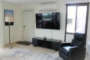 a living room with a chair and a tv at Modern Futuristic Hawaii Fortress condo in Honolulu