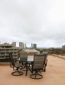 een tafel en stoelen op het dak van een gebouw bij Modern Futuristic Hawaii Fortress condo in Honolulu