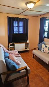a living room with a tv and a couch at Cozy Home in Volcán