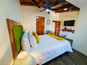 1 dormitorio con 1 cama y ventilador de techo en Sibu Lodge, en Monteverde