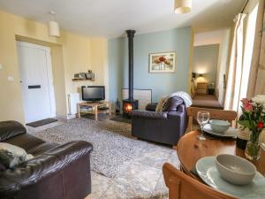 a living room with couches and a fire place at Carew in Llandysul