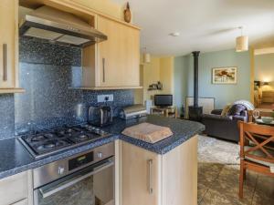 a kitchen with a stove top oven next to a living room at Carew in Llandysul