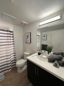 bagno con lavandino, servizi igienici e specchio di Hollywood Universal Studios Apartment FREE parking a Los Angeles