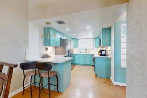 a kitchen with blue cabinets and two bar stools at Camino los Mochis in Tucson