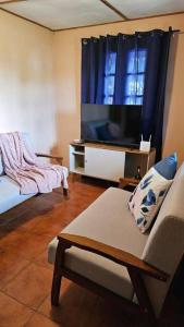 Cozy Home في فولكان: غرفة معيشة مع أريكة وتلفزيون بشاشة مسطحة