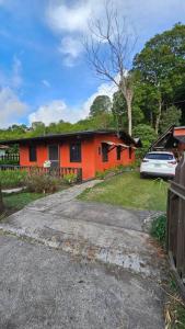 ein orangenes Haus mit einem davor geparkt in der Unterkunft Cozy Home in Volcán