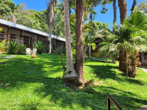 um resort com palmeiras em frente a um edifício em Pousada do Rodrigo em Macacos