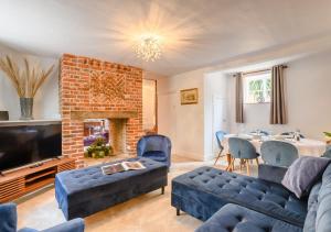 a living room with a couch and a fireplace at Grove Cottage in Horstead