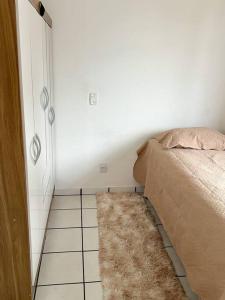 a bedroom with a bed and a rug on the floor at Apartamento próximo da Praia in Vila Velha