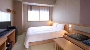 a bedroom with a white bed and a television at Onyado Nono Asakusa Bettei Hot Spring in Tokyo