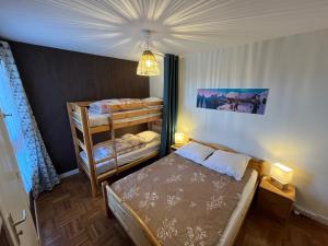 a bedroom with a bed and two bunk beds at Jouvencelles au pied des pistes in Prémanon