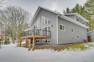 a large house with a deck on the side of it at Lakefront Rhinelander Cottage with Private Dock! in Rhinelander