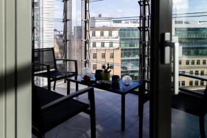 a table on a balcony with a view of a city at 3Bed 3Bath Apt with 2xBalconies in Central London in London