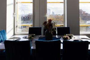 a dining room table with a vase of flowers on it at 3Bed 3Bath Apt with 2xBalconies in Central London in London