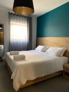 Un dormitorio con una gran cama blanca con una pared azul. en Village point Sliema 2 bedroom, en Sliema