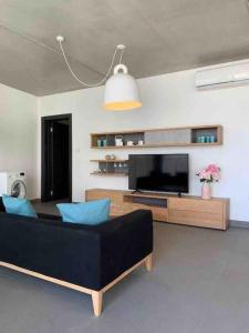 ein Wohnzimmer mit einem schwarzen Sofa und einem Flachbild-TV in der Unterkunft Village point Sliema 2 bedroom in Sliema