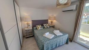 a small bedroom with a bed and two lamps at Casa Luna Blanca in Cala Gonone