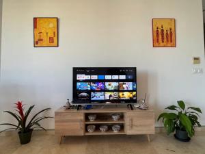a flat screen tv sitting on top of a wooden entertainment center at Luxe serein en Marina in Salé