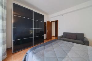 1 dormitorio con 1 cama grande y 1 sofá en Private parking - Family home - 15 min to Venice en Mestre