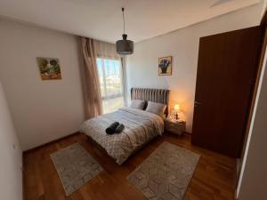 a bedroom with a bed and a window at Luxe serein en Marina in Salé