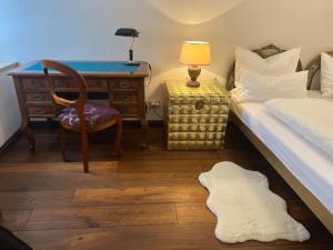 a bedroom with a bed and a desk and a bed and a chair at Schloß Hürbel Rosengarten - Suite in Gutenzell-Hürbel