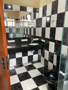 a bathroom with a black and white checkered floor at Refúgio Aconchegante e Espaçoso in Araguaína