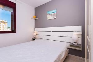 1 dormitorio con cama blanca y ventana en Apartamento Topacio 2 - PlusHolidays, en Calpe