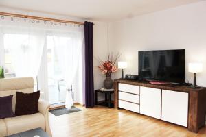un salon avec une télévision sur une commode dans l'établissement Ferienhaus im Bleitz, à Wrestedt