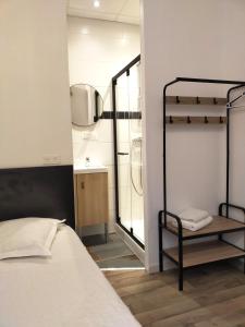a bedroom with a bunk bed and a bathroom at Au Nouvel Hôtel in Toulon
