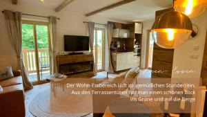 a living room with a couch and a tv at Lärchen-Chalet 2 in Winkl Heiligenblut