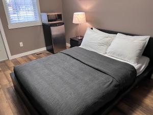 a bed in a bedroom with a lamp on a table at Riverside Condos by Fernie Central Reservations in Fernie