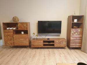 uma sala de estar com uma televisão de ecrã plano e mobiliário em madeira em Tále Apartmán E2 - Evergreen Tále em Tale