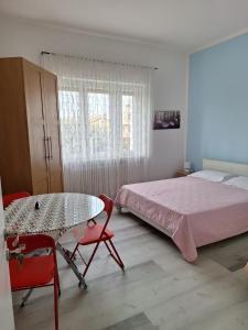 - une chambre avec un lit, une table et des chaises dans l'établissement Giada Rooms, à Peschiera del Garda