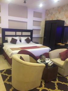 um quarto de hotel com uma cama e duas cadeiras em هوتيل المجاردة em Al Majaridah