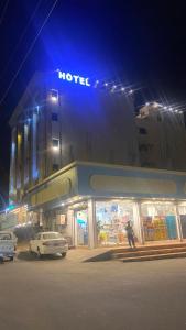 um hotel com carros estacionados em frente a ele à noite em هوتيل المجاردة em Al Majaridah