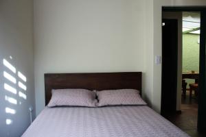 1 cama con cabecero de madera en un dormitorio en Casa Mostaza Pueblito Boyacense, en Duitama