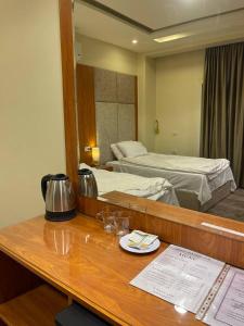 a hotel room with a desk with a bed and a mirror at Solima pyramids inn in Cairo