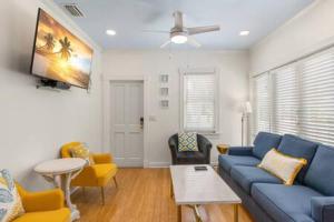 uma sala de estar com um sofá azul e cadeiras em Poolside Paradise by Brightwild em Key West