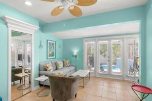 uma sala de estar com paredes azuis e um sofá em Poolside Paradise by Brightwild em Key West