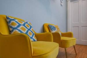due sedie gialle e uno sgabello in una stanza di Poolside Suite a Key West