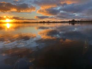 una puesta de sol sobre una gran masa de agua en Ferienwohnung Ostseestrandgut, en Ribnitz-Damgarten