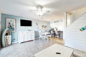 ein Wohnzimmer mit Fernseher und Tisch in der Unterkunft Panhandle Luxury D in Panama City Beach