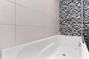y baño con ducha y bañera blanca. en 1 Bed- Hyde Park- Central London, en Londres