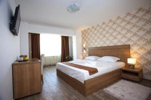 Habitación de hotel con cama y TV en Hotel Nova Residence, en Bucarest