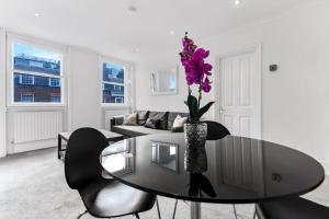 uma sala de estar com uma mesa com um vaso de flores em 1 Bed- Hyde Park- Central London em Londres