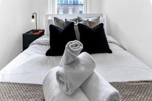 Una cama blanca con una toalla encima. en 1 Bed- Hyde Park- Central London, en Londres